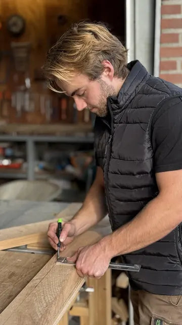 Rick Daniels tekent hout af in zijn werkplaats.